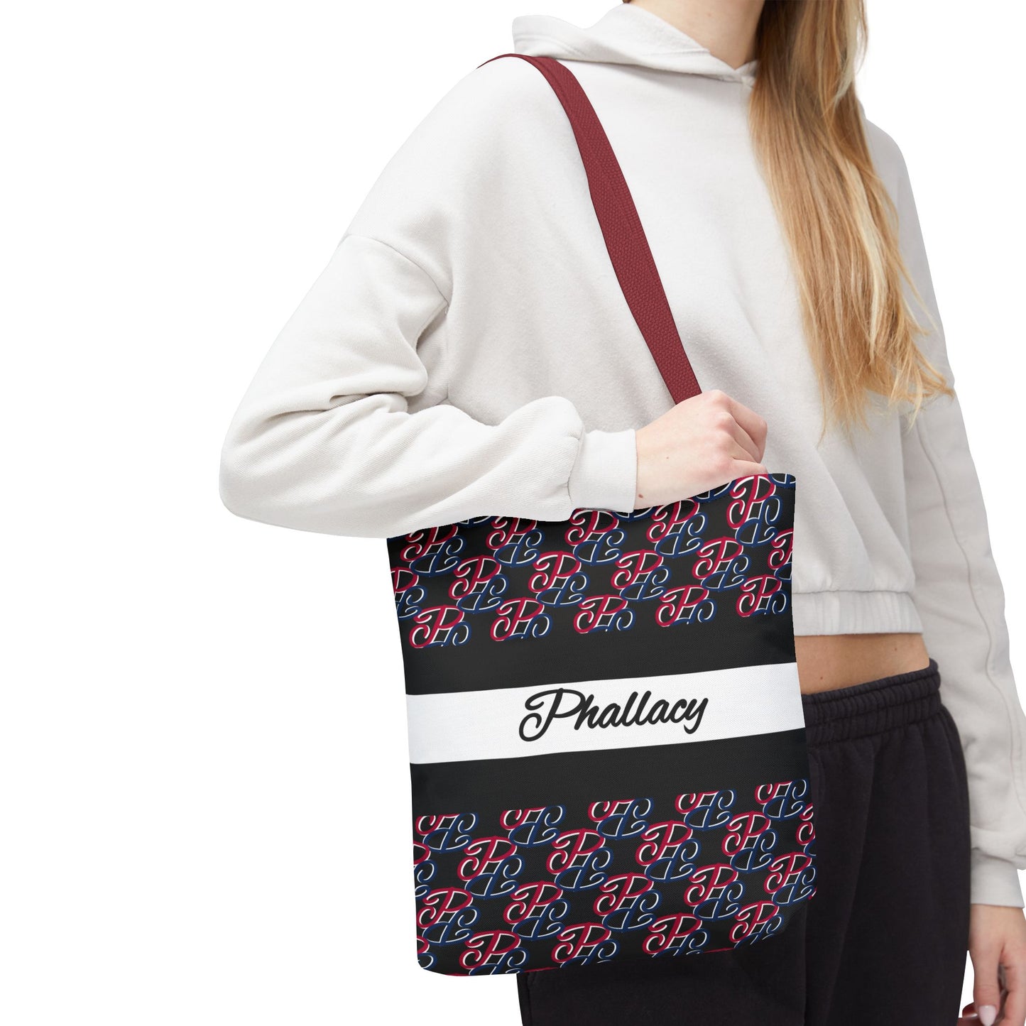 Woman wearing a white hoodie carrying a Phallacy designer tote bag with colorful monogram pattern and burgundy strap